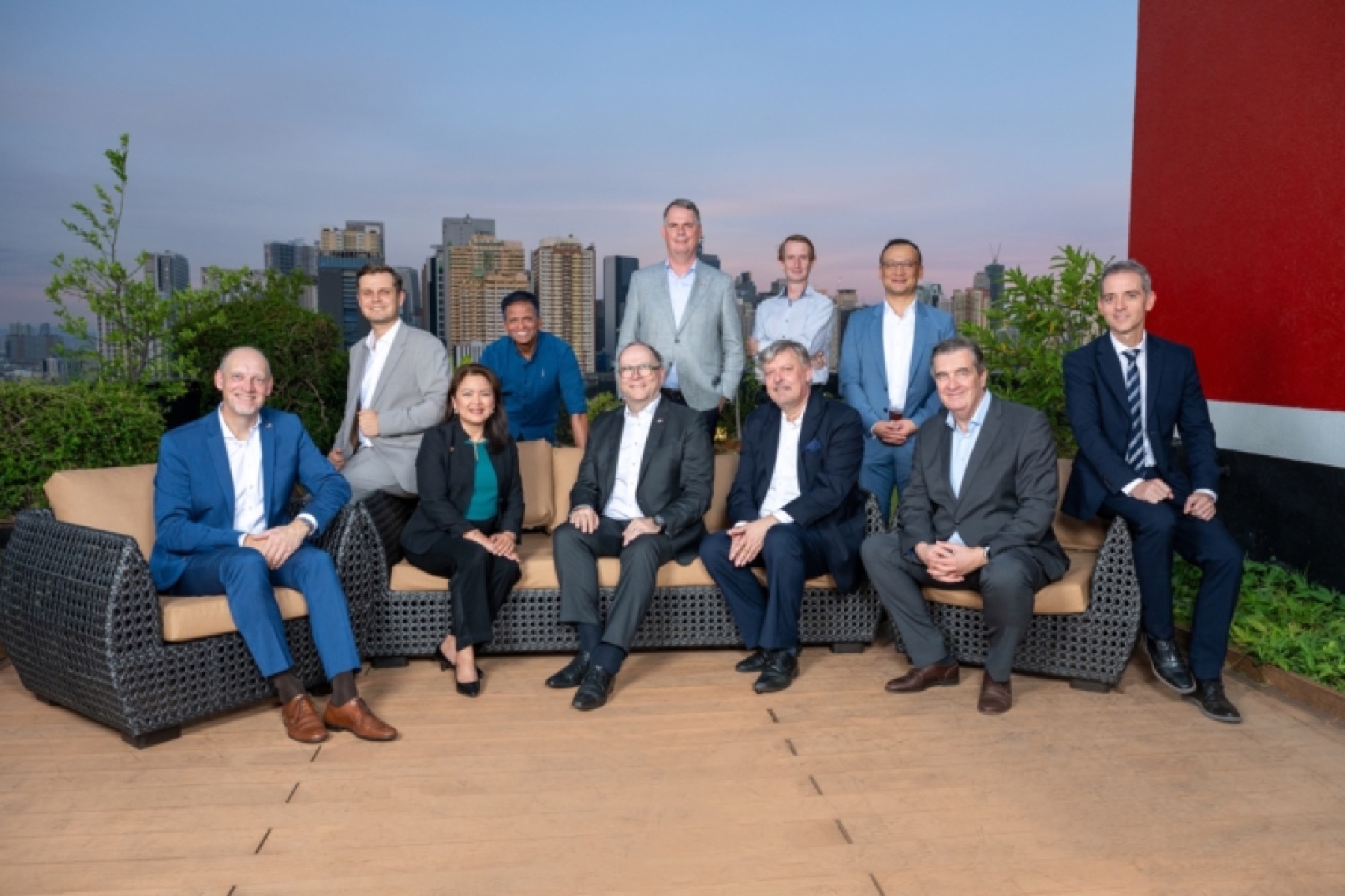 The Board of Directors photographed on a Makati roof terrace at dusk with the skyline behind them
